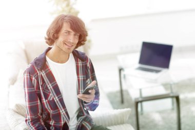 bulanık bir arka plan üzerinde bir akıllı telefon ile Modern adam.