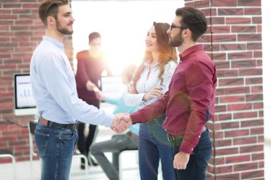 Ofiste meslektaşı ile işadamı el gülümseyen.