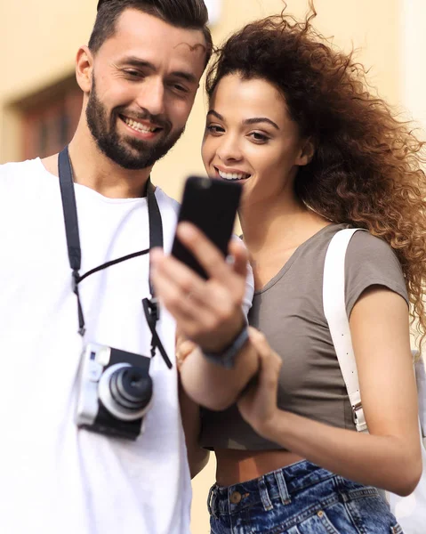 Feliz jovem casal em busca de localização tanto no telefone móvel — Fotografia de Stock