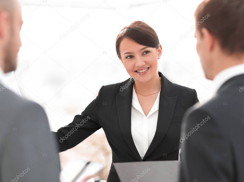 smiling businesswoman showing colleague information on the flipchart.