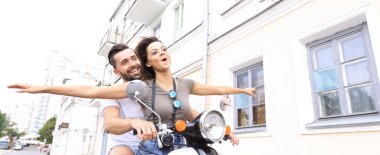 Güzel genç bir çift bir scooter sürme sırasında gülümsüyor