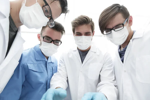 Primer plano. un equipo de médicos con máscaras protectoras . — Foto de Stock