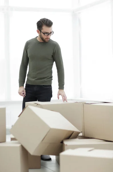 Homem olha para caixas em uma nova casa — Fotografia de Stock