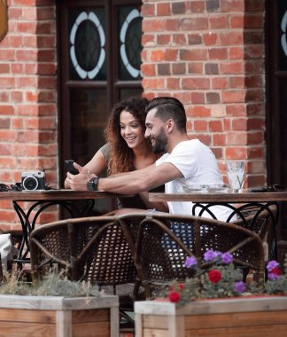 Genç bir çift bir kafe terasında oturup portresi