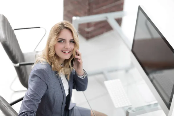 Succesvolle jonge zakenvrouw zitten aan een bureau — Stockfoto