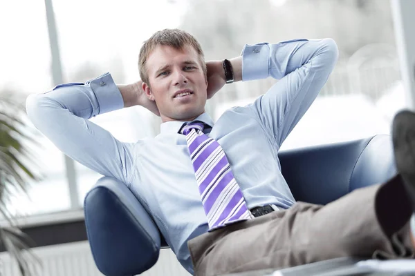 Jeune homme d'affaires penché sur sa chaise — Photo