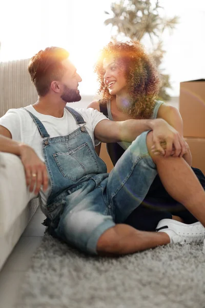 Jovem casal sentado no sofá e sonhando com o futuro — Fotografia de Stock