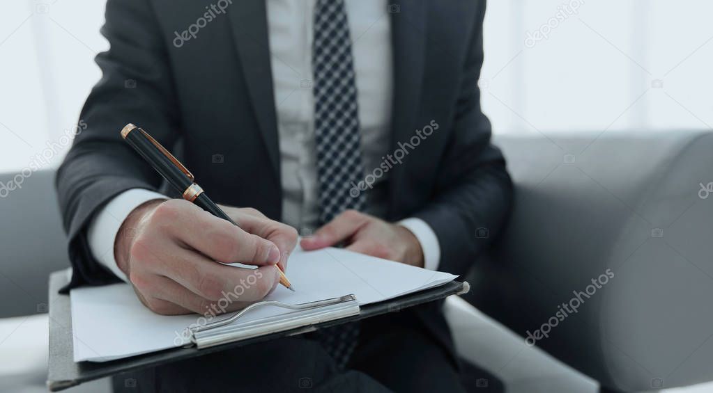 Businessman signs a contract. Holding pen in hand.