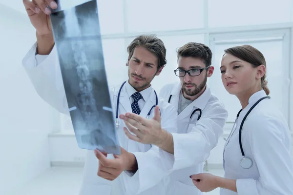 Tre medici fiduciosi esaminano una radiografia — Foto Stock