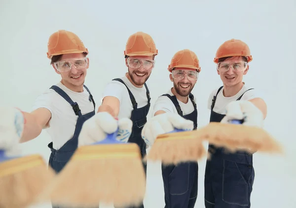 Sorrindo grupo de construtores com uma escova de tinta — Fotografia de Stock