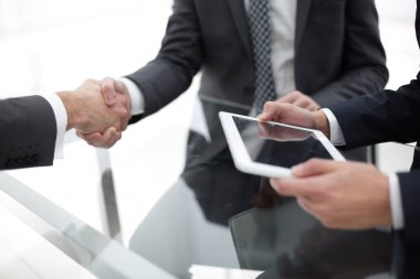 Bir toplantı sırasında el sıkışan iki emin iş adamları