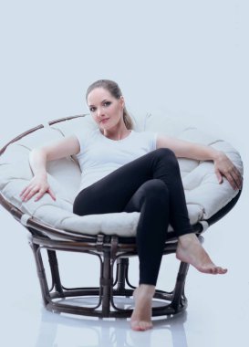 rattan ile dairesel bir sandalyede oturan genç kadın