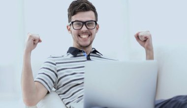 mutlu adam kanepede oturan dizüstü bilgisayar ile