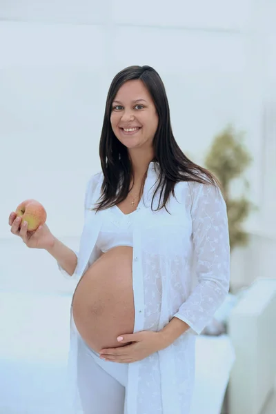 Lächelnde Schwangere mit einem Apfel — Stockfoto