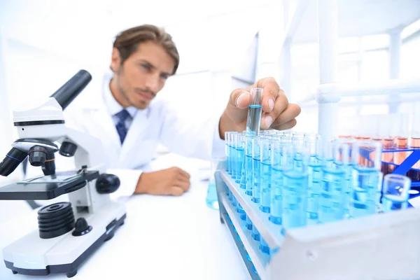 Scheikundige kijken naar test-buizen met blauw vloeistoffen — Stockfoto