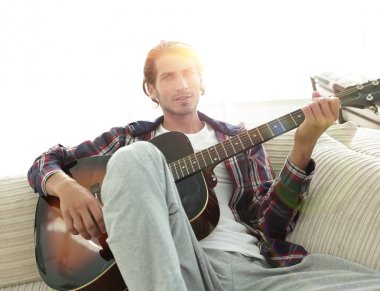 oturma odasında kanepede oturup gitar ile Modern adam.