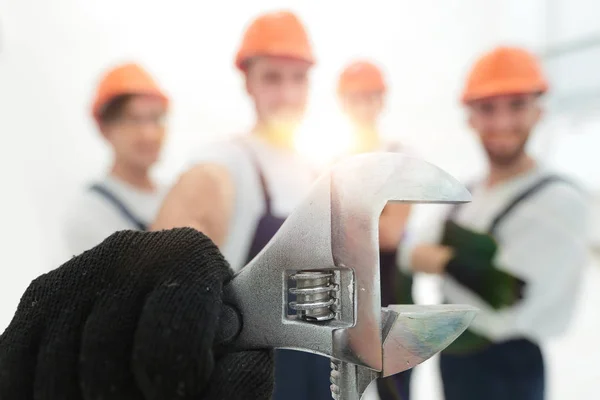 Primer plano. la llave en las manos de los constructores — Foto de Stock