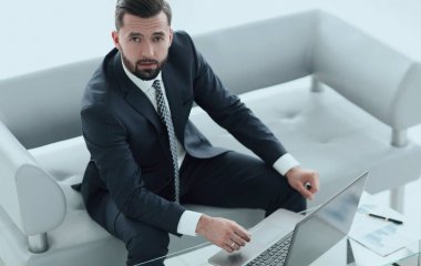 mali grafikler ile bir dizüstü bilgisayar üzerinde çalışan iş adamı