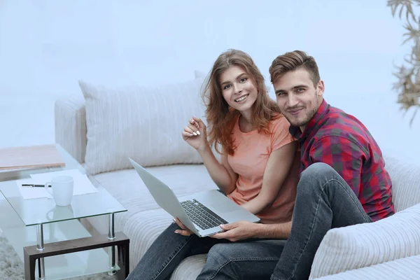 Paar studenten met een laptop zittend op de bank — Stockfoto