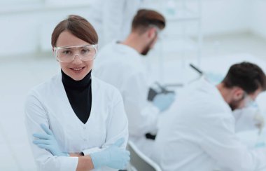 Laboratuvar arka planda bilim adamı portresi.