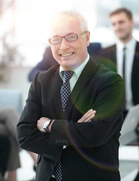 Lachende senior zakenman op de achtergrond van business team — Stockfoto