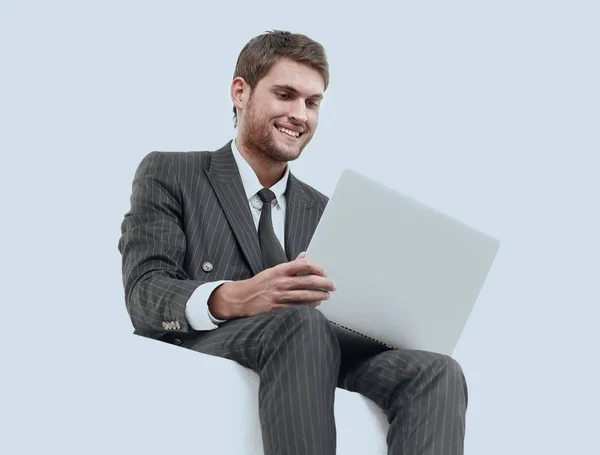 Handsome young business man sitting on a white modern chair — Stock Photo, Image