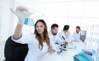 Grup genç bilim adamı laboratuvarda çalışan.