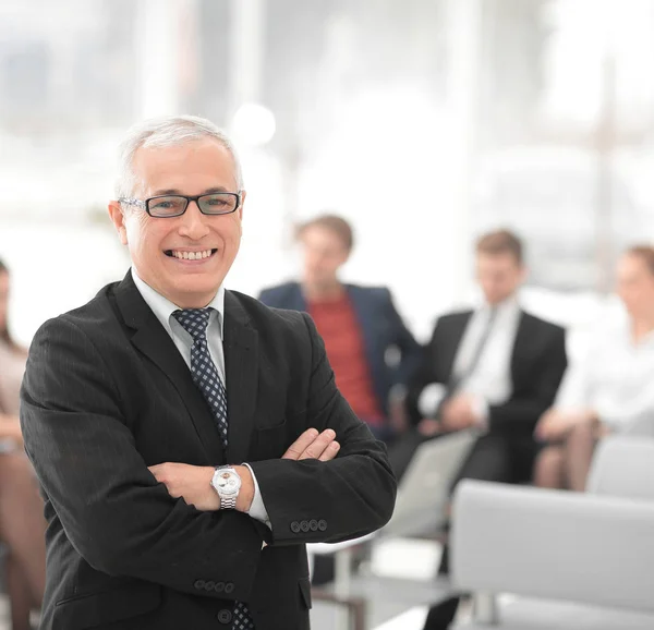 Smiling senior boss in the background of the office — Stock Photo, Image