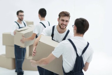 Kutu üzerinde beyaz backgro izole gülümseyen tutan Nakliyeciler portresi