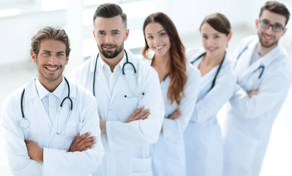 Equipe médica de pé com os braços cruzados em um fundo branco — Fotografia de Stock