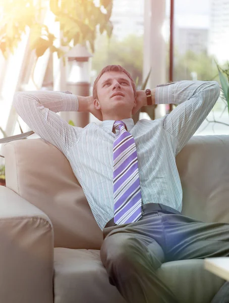 Sério bonito empresário relaxante no lobby — Fotografia de Stock