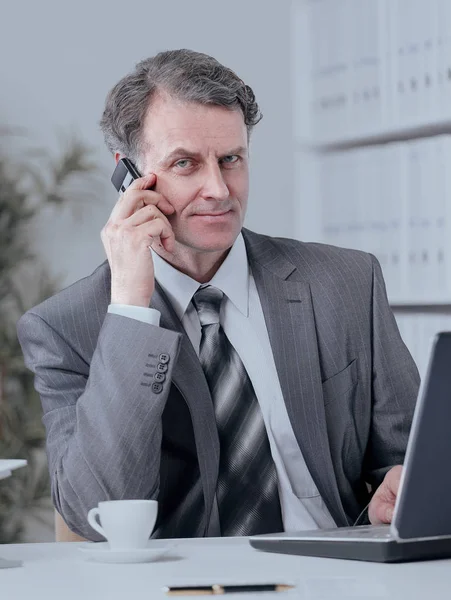 Empresario teniendo conversación telefónica en el lugar de trabajo — Foto de Stock
