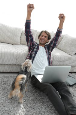 geniş oturma odasında Skordan dizüstü bilgisayar ile mutlu adam.