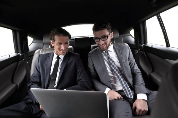 Бизнес-партнеры, сидящие в роскошном автомобиле — стоковое фото