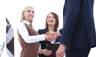 başarılı bir sunum sonrası el sıkışan iş arkadaşları.