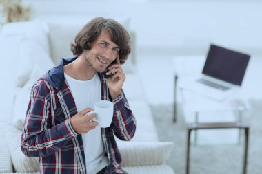 güzel bir fincan adamla bir dizüstü bilgisayar önünde oturur.