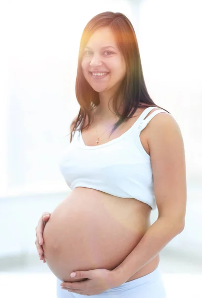 Gros plan d'une femme enceinte mettant ses mains sur son ventre . — Photo