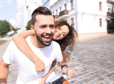 Mutlu çift sürme vintage scooter açık havada.