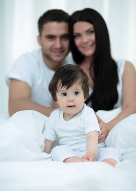 mutlu çift ve yatakta oturmuş oğul