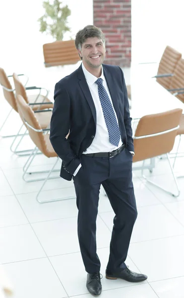 Homem de negócios de pé em uma sala de reuniões vazia — Fotografia de Stock