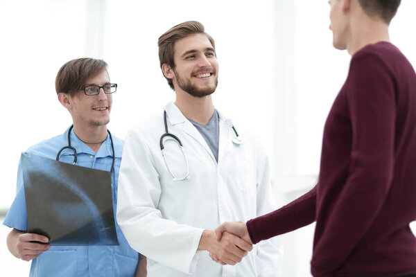 smiling doctor shaking hand of a patient