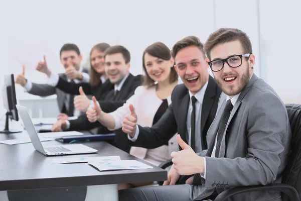 Бизнес-команда с большим пальцем вверх, сидя за рабочим столом — стоковое фото