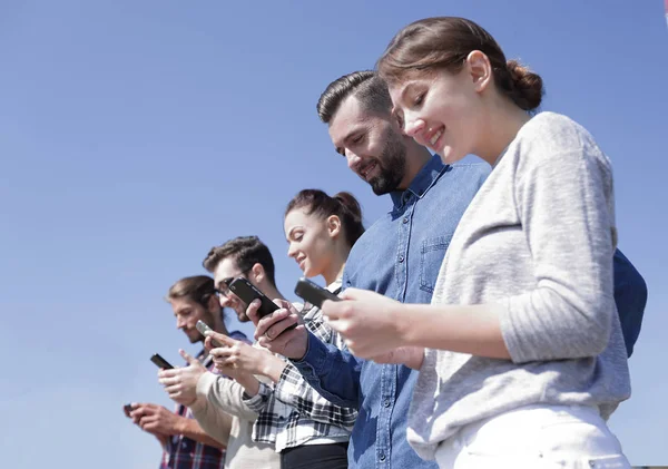 Les jeunes utilisant des smartphones pour rechercher un réseau — Photo