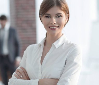 Ofisin arka planında genç iş kadınının portresi var.