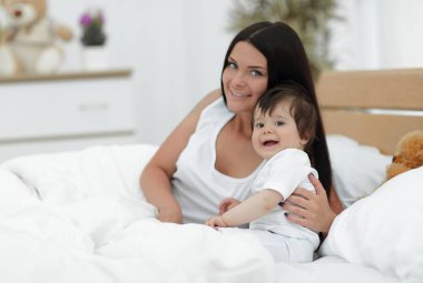 Güzel bir anne ile bebeği yatak odasında portresi