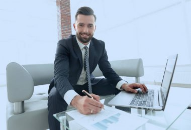 İş grafikleri ile bir dizüstü bilgisayar üzerinde çalışan iş adamı