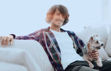 şık adam köpeğiyle kanepede oturan.