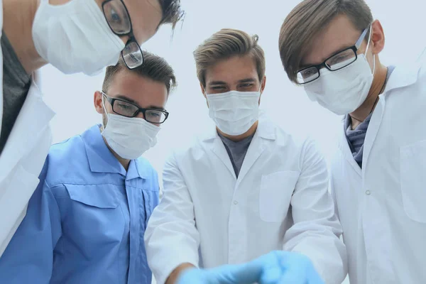 Primer plano. un equipo de médicos con máscaras protectoras . —  Fotos de Stock