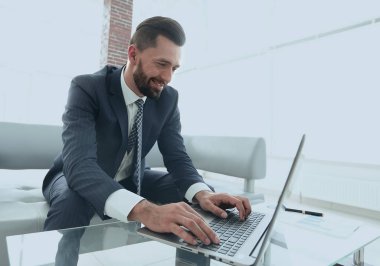 Modern ofis dizüstü bilgisayarda çalışan başarılı erkeğin