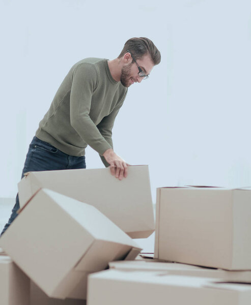 уверенный человек распаковывает коробки в новом доме
